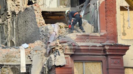 Städtische Arbeiter räumen Trümmer aus einem Wohnhaus, das am 18.10.2023 von einer Rakete getroffen wurde.