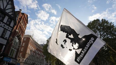 Eine Fahne mit dem Konterfei von Julian Assange wird bei einer Demonstration vor dem Royal Courts of Justice in London geschwenkt.