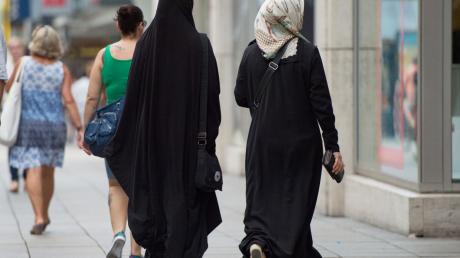 Zwei Frauen mit Kopftuch und langer Oberbekleidung.
