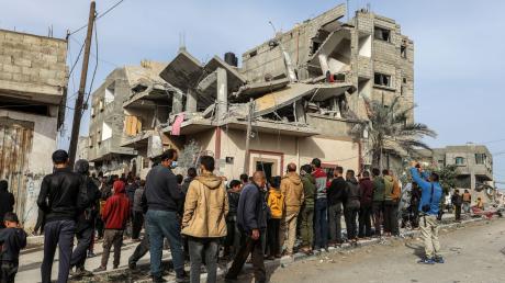 Menschen versammeln sich nach einem israelischen Luftangriff in Rafah um das zerstörte Haus einer Familie.