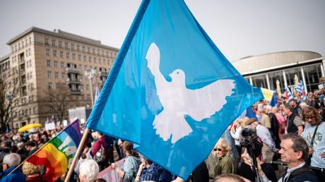 Eine Flagge mit der Friedenstaube ist auf dem traditionellen Ostermarsch in Berlin zu sehen.