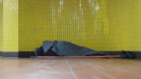 Ein Obdachloser liegt in seinem Schlafsack in einer U-Bahnstation in der Hamburger Innenstadt. 17,7 Millionen Menschen waren 2023 in Deutschland von Armut oder Ausgrenzung bedroht.