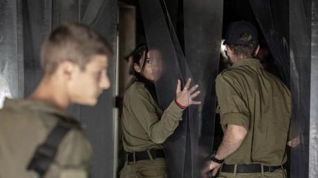 Israelische Soldatinnen und Soldaten besichtigen eine zerstörte Einrichtung im Kibbuz Nir Oz, eine der israelischen Gemeinden, die am 7. Oktober von der Hamas angegriffen wurden.