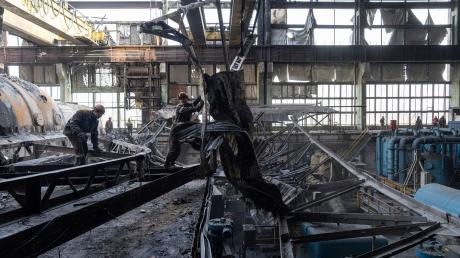 Arbeiter räumen die Trümmer nach einem russischen Raketenangriff auf ein DTEK-Kraftwerk in der Ukraine auf.