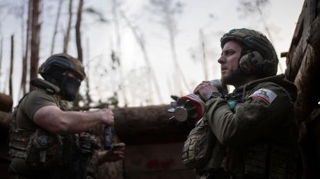 Ein ukrainischer Soldat trägt eine Mörsergranate, während er auf einen Feuerbefehl wartet.