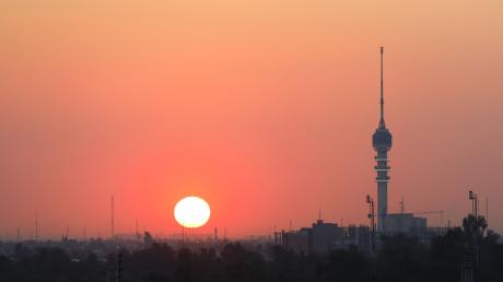 Die Sonne geht hinter der Skyline von Bagdad unter.