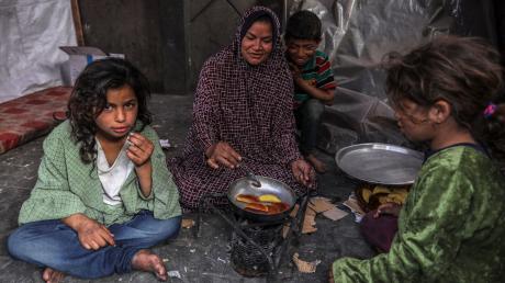 Eine palästinensische Familie kocht in einem behelfsmäßigen Zelt in Rafah.