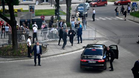 Leibwächter bringen den slowakischen Ministerpräsidenten Robert Fico in einem Auto vom Ort des Geschehens in Sicherheit.