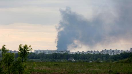 Nach dem Beschuss durch russische Truppen steigt eine Rauchsäule hinter Wohnhäusern in Charkiw auf.