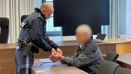 Kurz vor Prozessbeginn am Dienstag am Landgericht Memmingen nimmt ein Polizist dem Angeklagten die Handschellen ab.