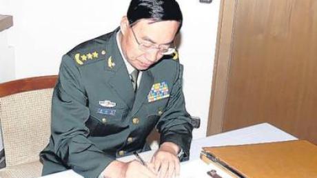 General Qinsheng Zhang trägt sich in das Gästebuch ein.  