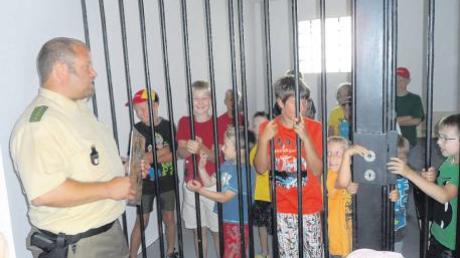 Ein bisschen Überwindung hat es die Kinder schon gekostet, in die Gefängniszelle zu gehen. Polizeihauptmeister Michael Miller (links) führte die jungen Gäste durch das Gebäude.  