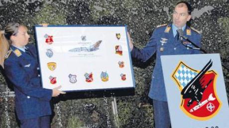 Eine Tafel mit allen Wappen des Standorts überreichten dem Kommodore Oberleutnant Jennifer Greathouse (links) und Oberstleutnant Thomas Dohler. 