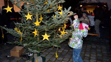 Wünsche, die man nicht kaufen kann, schrieben Kinder und ihre Eltern auf Sterne und hängten diese an den Weihnachtsbaum in der Siedlung.   