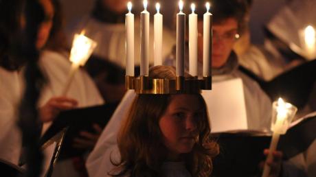 Beim Santa Lucia-Singen tragen die Chorsänger Kerzen und sind in weiße Gewänder gekleidet.  