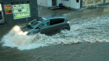 Die Lindauer Straße in Bobingen war so hoch überspühlt, dass die Autos dort Wellen schlugen und as Wasser in die Läden drang. Foto Dieminger, Foto-Hirche 