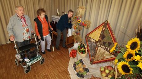 Doris Hivner (rechts), die frühere Mesnerin von St. Ulrich, hat heuer zum Erntedankfest für das AWO-Seniorenheim ein Körnerbild geschaffen und mit Früchten aus Feld und Garten dekoriert. 
