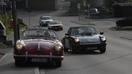 Zwei Generationen Porsche auf einem Bild: links ein 356, rechts der Nachfolger, ein 911 Targa.  
