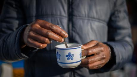 Ein Flüchtling hält eine Tasse mit Kaffee in den Händen. Foto: Ole Spata/dpa +++(c) dpa - Bildfunk+++