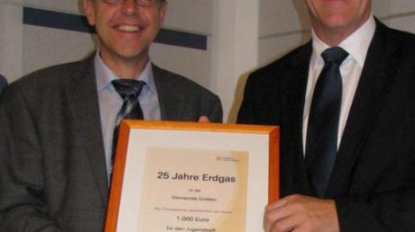 Klaus-Peter Dietmayer (rechts), der Geschäftsführer von Erdgas Schwaben, hat Bürgermeister Andreas Scharf eine Spende von 1000 Euro für die Ausstattung des neuen Jugendtreffs überreicht.