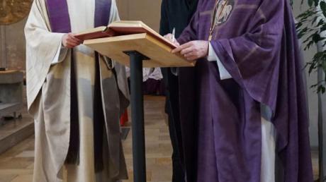 Weihbischof Anton Losinger trägt sich nach der Messe in St. Michael ins Goldene Buch der Stadt Schwabmünchen ein. Rechts neben ihm Bürgermeister Lorenz Müller und Stadtpfarrer Christoph Leutgäb. 	