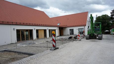 Der Gemeindesaal im Vordergrund und das Pfarrhaus sind fertiggestellt. Nun werden die Außenanlagen gebaut. 	