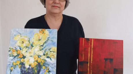 Margit Hafner mit zwei ihrer Werke, die auch bei der Ausstellung im Quartierstreff Bobingen Siedlung zu sehen sind. Das rechte Bild gehört zu ihrer Serie mit der Farbe Rot und trägt den Titel „Schwarz-Rot-Gold“.