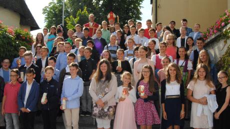 Mit Weihbischof Wörner stellten sich die gefirmten Jugendlichen an der Kirche zum Erinnerungsfoto auf. 	