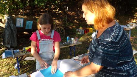 Künstlerin Nickel Altmann (rechts) zeigte Kindern wie Katharina, wie Fadenbilder gefertigt werden. 	<b>Foto: Karin Marz</b>
