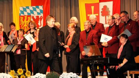 Siegfried Lauter dirigiert den Obermeitinger Singkreis, Silvia Landherr (rechts) begleitet am Klavier und der Vorsitzende Gottfried Riedmiller (dahinter) singt selbst mit.