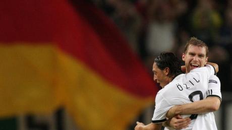Mesut Özil (l) und Per Mertesacker freuen sich auf die EM 2012 in Polen und der Ukraine. Foto: Rolf Vennenbernd dpa
