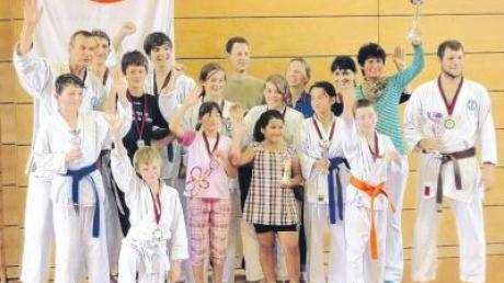 Dojoleiter Andreas Mayr (links) überreichte den einzelnen Karatesiegern die Pokale. Von rechts Michael Koschta und Brigitte Wagmann bei den Erwachsenen und vorne die siegreichen Jugendlichen und Kinder. 