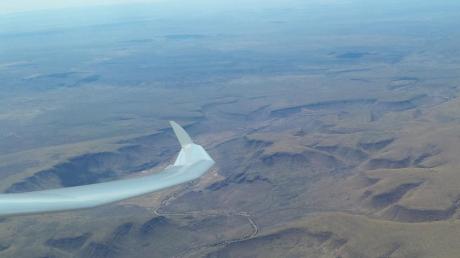 Segelfliegen über der namibischen Wüste (linkes Foto) ist landschaftlich eher eintönig, aber für weite Flüge ohne Motorkraft ideal. Abwechslungsreicher ist dagegen Segelfliegen über der Großstadt (rechtes Foto): SFG-Pilot Arne Röpling erkundet derzeit Chile aus der Luft.  