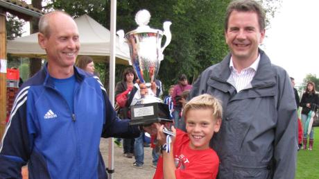 Turnier-Organisator Thomas Lussi (links) und 2. Bürgermeister Stefan Welzel (rechts) übergaben den FCW-Kapitän Marcel Ohmann den Gerd-Mewes-Pokal.