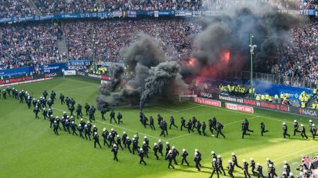 Hundertschaften der Polizei stürmten das Spielfeld, als Chaoten kurz vor Spielschluss Rauchbomben gezündet hatten. Das Spiel konnte trotzdem beendet werden, doch diese Bilder werden vom Abstieg des Hamburger SV in Erinnerung bleiben. 	