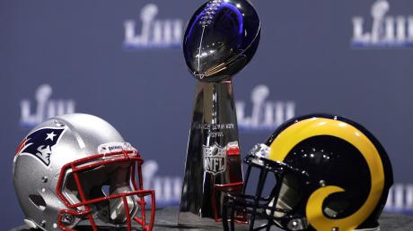 Die New England Patriots (linker Helm) kämpfen gegen die Los Angeles Rams um die Vince-Lombardi-Trophy, benannt nach dem Head Coach des ersten Super Bowl-Gewinners 1967, den Green Bay Packers. 	
