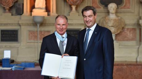 Bayerns Ministerpräsident Markus Söder ehrte FCA-Manager Stefan Reuter mit dem Bayerischen Verdienstorden. 	