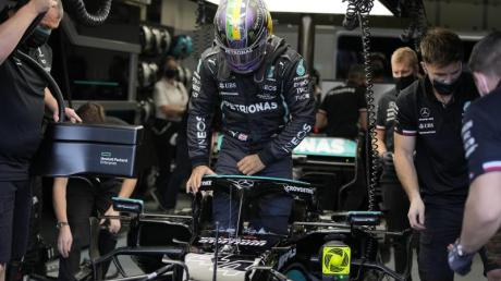 Der britische Mercedes-Pilot Lewis Hamilton steigt in seinen Rennwagen.