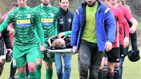 Das ist Sportkameradschaft: Spieler des FC Burlafingen und der SGM Ingstetten/Schießen tragen gemeinsam den verletzten Christoph Blaschke vom Feld.  	