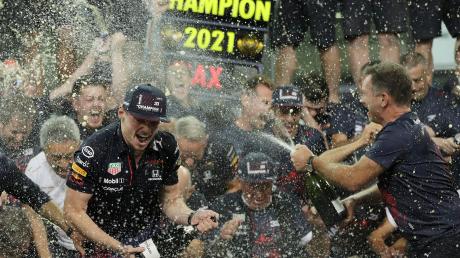 Red-Bull-Teamchef Christian Horner (rechts) macht den neuen Weltmeister Max Verstappen nass. 	