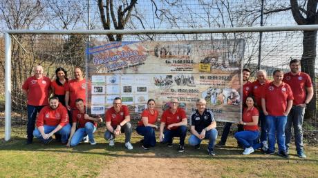 Einige der insgesamt 300 ehrenamtlichen Helfer und Helferinnen beim Heidewitzka-Festival präsentieren stolz das Plakat, auf dem die Mammut-Veranstaltung angekündigt wird.  
