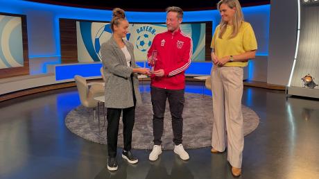 Von Vize-Europameisterin Lena Magull (links) und Moderatorin Julia Scharf bekam  Repasky bei „Blickpunkt Sport“ die Trophäe für den Bayern-Treffer des Monats September überreicht.