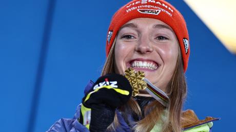 Katharina Althaus präsentiert und ihre WM-Goldmedaille.