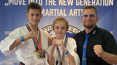 Zwei Weltmeister aus der Sportschule Bushido in Kötz: Lukas Basl und Jan gewannen in Schwabmünchen Gold. Harald Folladori, Präsident des World Martial Arts Committee, gratuliert.