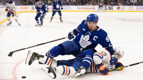 Adam Henrique von den Edmonton Oilers verliert den Zweikampf um den Puck mit John Tavares (oben) von den Toronto Maple Leafs.