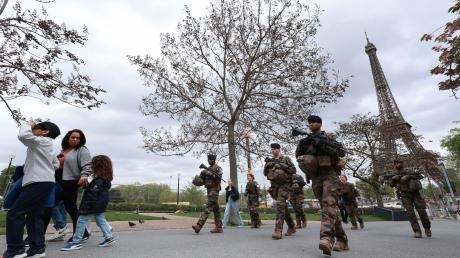 Soldaten patrouillieren entlang einer Baustelle für die bevorstehenden Olympischen Spiele in den Trocadero-Gärten gegenüber des Eiffelturms.