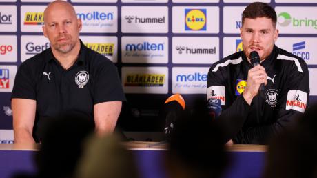 Axel Kromer (l) und Kapitän Johannes Golla sitzen während einer Pressekonferenz auf dem Podium.
