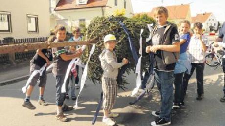Blaue und weiße Bänder befestigen die Kinder und Jugendlichen aus Gottmannshofen an der Krone ihres Maibaums. 