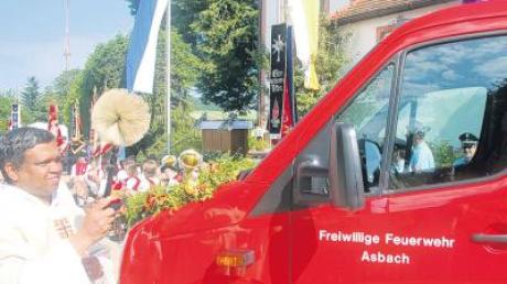 Pfarrer Joseph Kaniamparambil (links) erteilte dem neuen Asbacher Tragkraftspritzenfahrzeug VW-Crafter den kirchlichen Segen. 