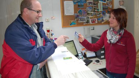 Thomas Englisch übergibt der Sprechstundenhelferin der Praxis Dr. Nuber in Wertingen, Silvia Winkler, seine Versicherungskarte. 